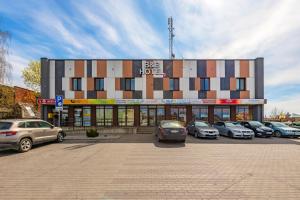 a building with cars parked in a parking lot at Air Kaunas in Karmėlava