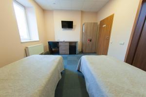 a hotel room with two beds and a desk at Air Kaunas in Karmėlava