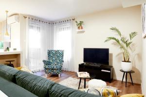 ヴロツワフにあるCleopatra Apartmentのリビングルーム(緑のソファ、テレビ付)