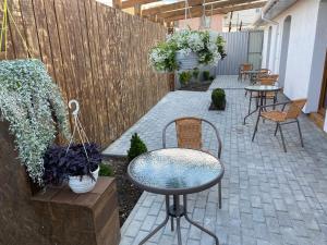 eine Terrasse mit Tischen, Stühlen und einem Zaun in der Unterkunft 4rooms in Winnyzja