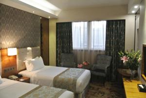 una camera d'albergo con due letti e una sedia di Holiday Inn Express Xiamen Lushan -Shopping Center, an IHG Hotel a Xiamen