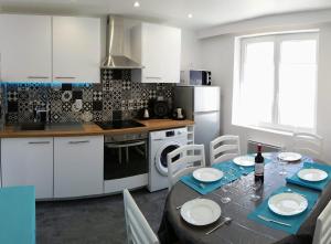 cocina con mesa y cocina con armarios blancos en TERRASSE -100 m PLAGE - GRAND APPARTEMENT-8 PERS, en Berck-sur-Mer