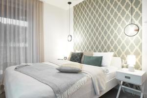 a bedroom with a white bed and a wall at Cleopatra Apartment in Wrocław