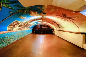 une piste de bowling ornée d'une fresque murale représentant des palmiers. dans l'établissement Hotel Havana, à Mayence