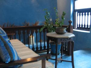 a room with a bench and a table with a plant at Shaba Boutique Hotel in Zanzibar City