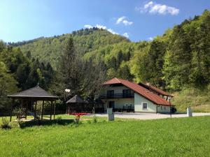 a house in a field with a gazebo at Guest House Atelšek in Rečica ob Savinji