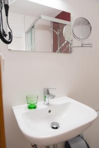 a white sink with a mirror and a glass on it at Landgasthof Waldesruh in Gallspach