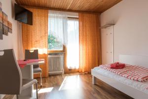 a bedroom with a bed and a desk and a window at Landgasthof Waldesruh in Gallspach