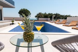 una piña en una mesa de cristal junto a una piscina en Villa Helena en Trogir
