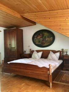 a bedroom with a large bed with a painting on the wall at Guest House Atelšek in Rečica ob Savinji