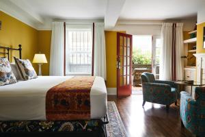 Habitación de hotel con cama y silla en Petite Auberge, en San Francisco