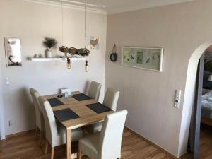 a dining room with a wooden table and chairs at Haus Solymar App. Meerblick in Grömitz