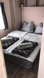מיטה או מיטות בחדר ב-Luxe Chalet op camping Duindoorn, IJmuiden aan Zee, in de buurt van F1 circuit Zandvoort en Bloemendaal op loopafstand strand