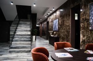 a lobby of a building with a table and chairs at Hotel Ub Business & Wellness in Ub