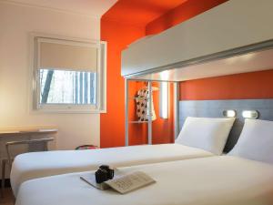 
a hotel room with a bed and a television at ibis budget Amsterdam Airport in Badhoevedorp
