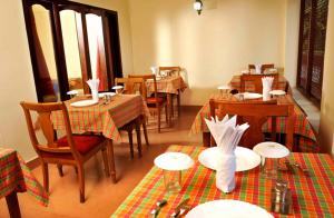 un restaurante con mesas y sillas en una habitación en Vijaya Varma Beach Resort, en Kovalam