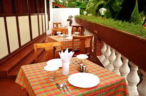 a table on a balcony with two tables and chairs at Vijaya Varma Beach Resort in Kovalam