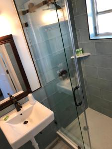 a bathroom with a sink and a glass shower at The Pelican Key Largo Cottages in Key Largo