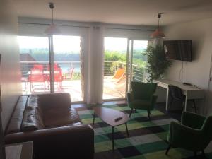 a living room with a couch and chairs and a balcony at Appartement avec grande terrasse pour 6 personnes in Athis-Mons