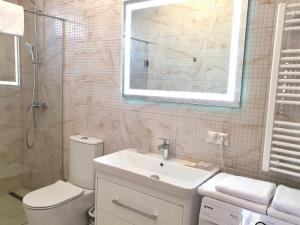 a bathroom with a sink and a toilet and a mirror at Apartment Sweethome 1 FREE PARKING in Uzhhorod