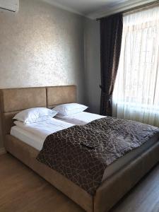 1 cama grande en un dormitorio con ventana en Apartment Sweethome 1 FREE PARKING, en Uzhhorod