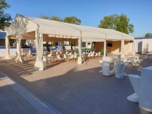 a tent with white chairs and tables under it at Hotel La Villoría in Medina Sidonia