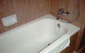 uma banheira branca na casa de banho com um chuveiro em Bangkok City Suite em Bangkok