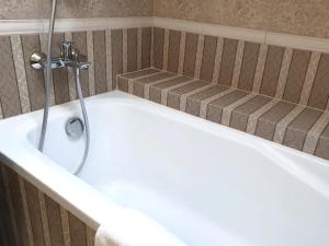 a bath tub with a shower in a bathroom at Apartment Sweethome 3 FREE PARKING in Uzhhorod