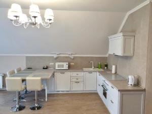 a kitchen with white cabinets and a table with chairs at Apartment Sweethome 3 FREE PARKING in Uzhhorod +6 photos