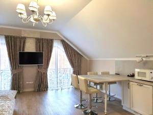 a dining room with a table and chairs and a tv at Apartment Sweethome 3 FREE PARKING in Uzhhorod