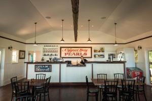 un restaurante con mesas y sillas y un bar en Cygnet Bay Pearl Farm, en Dampier Peninsula