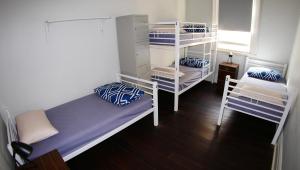 a room with two bunk beds and a window at Geraldton Backpackers in Geraldton