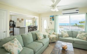a living room with a green couch and chairs at Villa Turkuaz in Providenciales