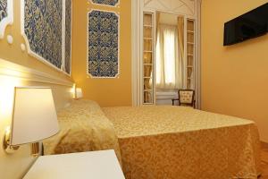 Habitación de hotel con cama y TV en DG Prestige Room, en Roma