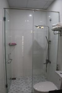 a glass shower in a bathroom with a toilet at Hồng Hạc Hotel in Tuy Hoa +36 photos
