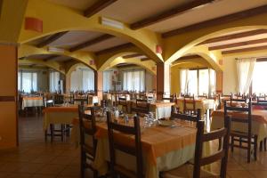 - un restaurant avec des tables et des chaises dans une salle dans l'établissement Albergo Ristorante Pizzeria Monte Arcosu, à Uta