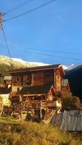 a wooden cabin with a snow covered mountain in the background at Gîte l'Ermitage in Veysonnaz