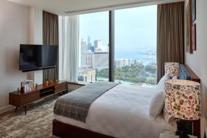 a hotel room with a bed and a tv at Little Tai Hang in Hong Kong