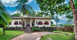 a white house with palm trees in front of it at Villa Karamoja in Koggala