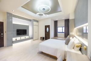 馬公市的住宿－藍海天晴，一间大卧室,配有白色的床和电视