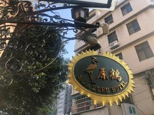 um sinal para um hotel rural pendurado em frente a um edifício em Hara Zuru Hotel em Taoyuan