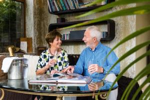 an older man and woman sitting at a table with wine glasses at Blackwell House in Banbridge