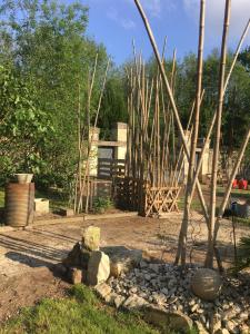 einen Garten mit Felsen und Bäumen und einem Zaun in der Unterkunft Moulin De Coupigny in Fontenille-Saint-Martin-d'Entraigues