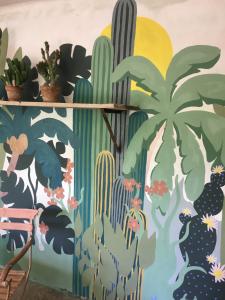 a mural of cacti and palm trees on a wall at Moulin De Coupigny in Fontenille-Saint-Martin-d'Entraigues