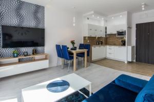 a living room with a blue couch and a table at Apartamenty Izerskie - ul. Sienkiewicza 9 in Świeradów-Zdrój
