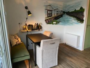 a dining room with a table and a painting on the wall at Bed & Breakfast Aalsmeer in Aalsmeer