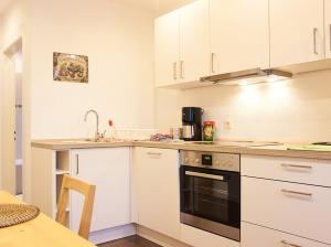 een keuken met witte kasten en een zwarte oven bij Apartments Ho30 in Stuttgart
