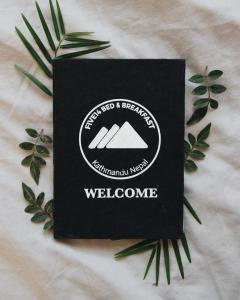 a black welcome sign sitting on top of a blanket at Five14 B&B in Pātan