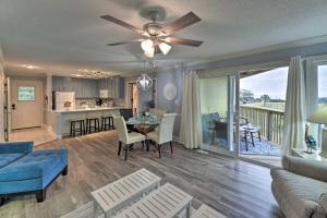 a living room with a blue couch and a dining room at Bright Emerald Isle Condo with Private Beach Access! in Emerald Isle