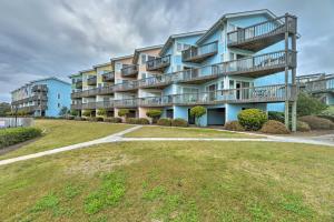 un gran edificio de apartamentos con balcones y patio en Bright Emerald Isle Condo with Private Beach Access! en Emerald Isle